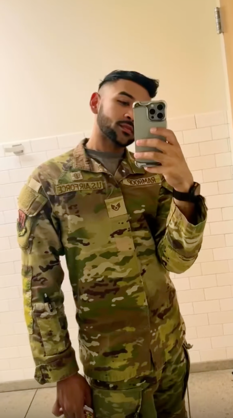 A man in a U.S. Air Force camouflage uniform takes a mirror selfie.